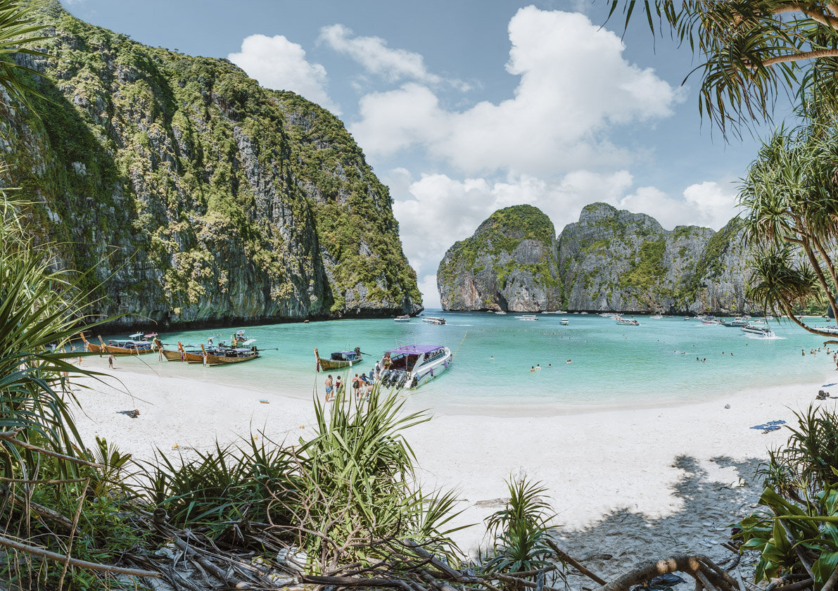 Boats docked in Phuket with a turquoise sea and cliffs ahead - Things to do on your 7 days in thailand itinerary
