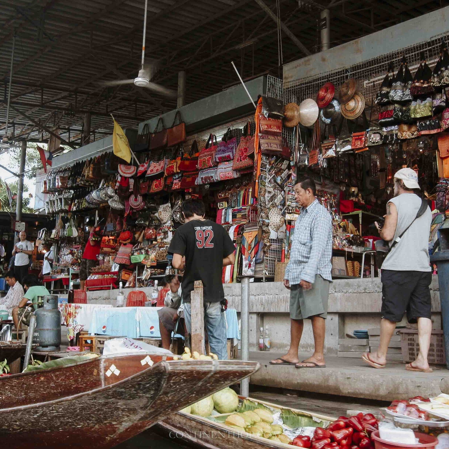 People buying vegetable and goods at a floating market - Things to do on your 7 days in thailand itinerary