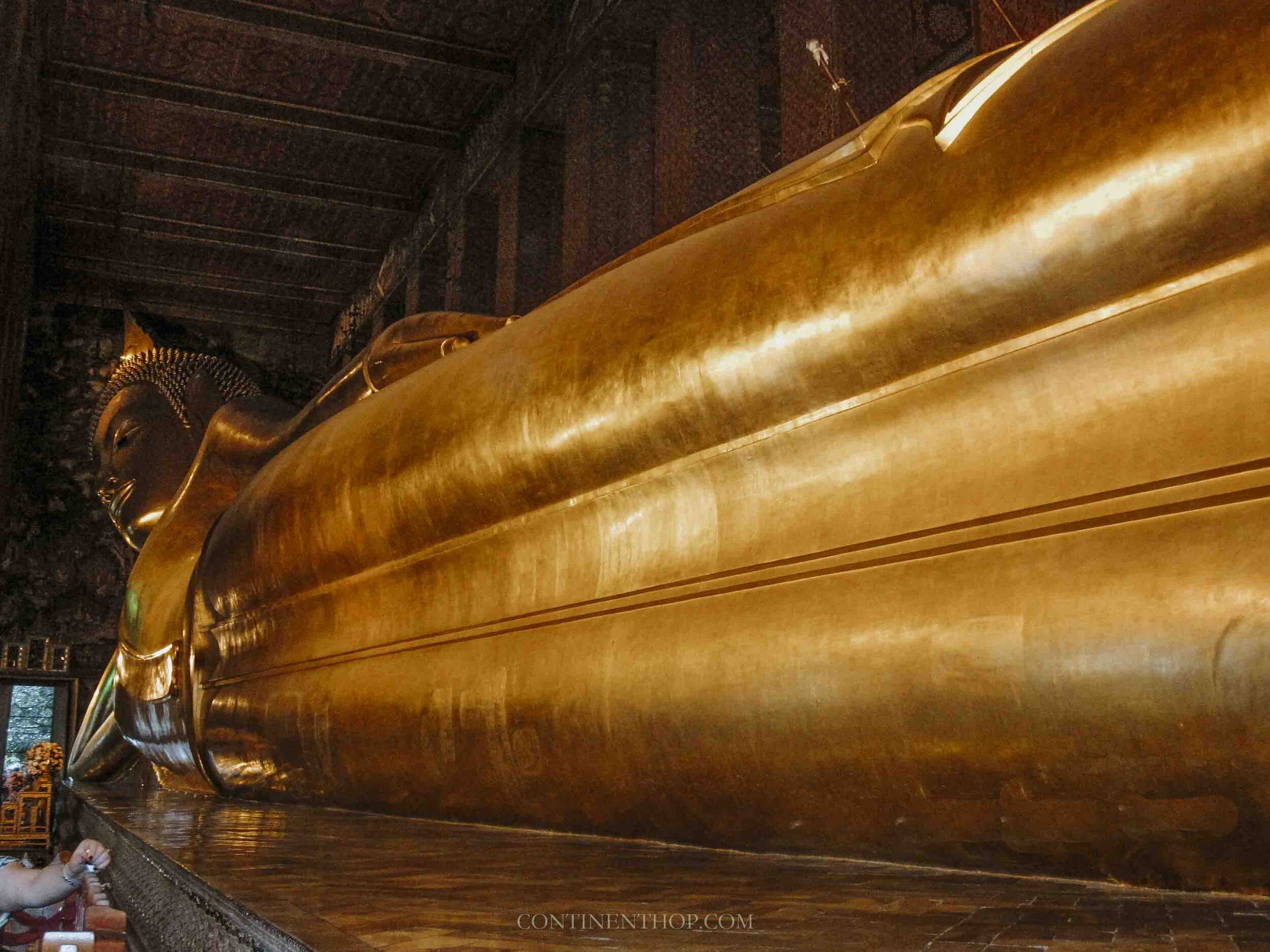 A very long Golden sleeping Buddha at Wat Pho - Things to do on your 7 days in thailand itinerary
