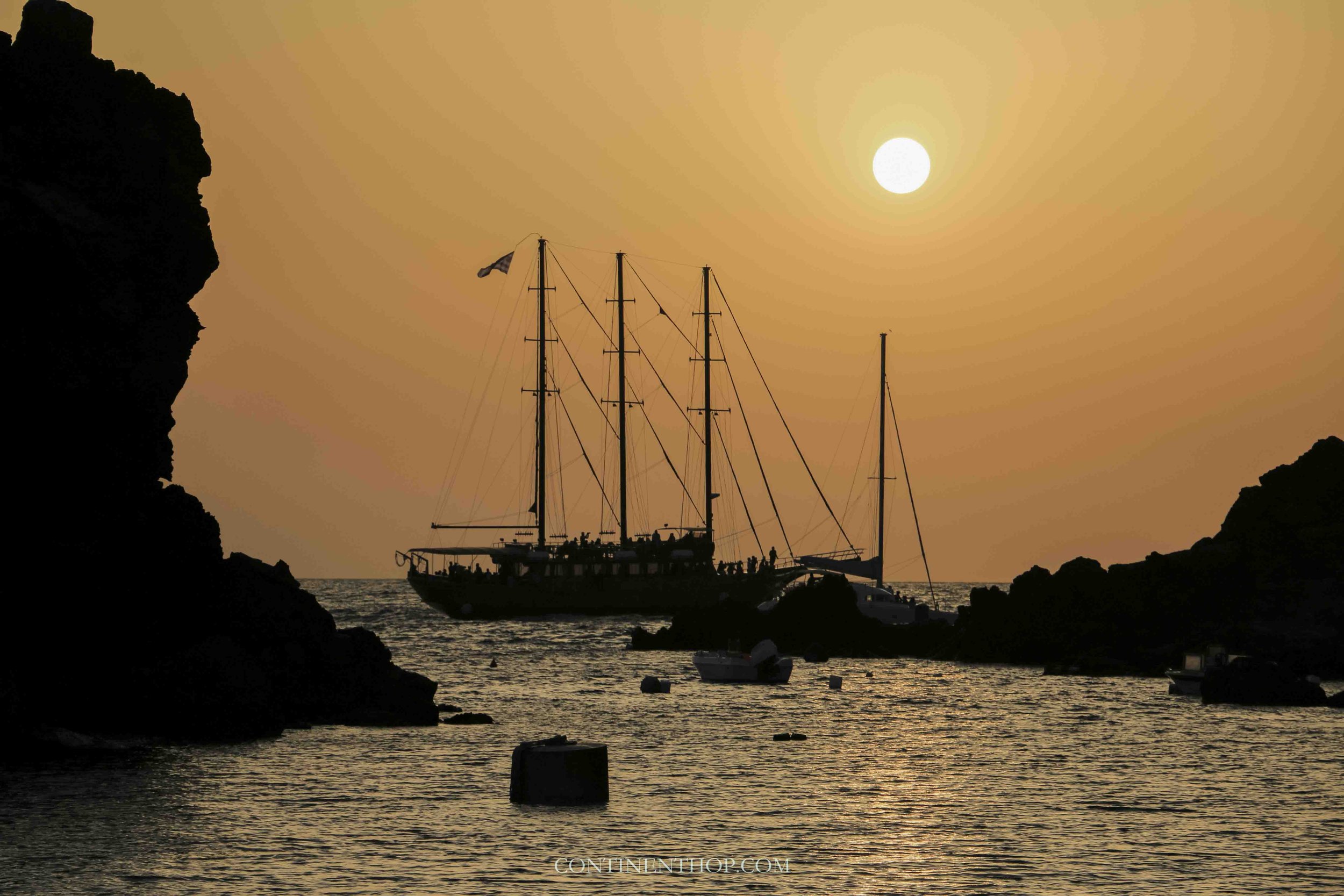 silhouette of boats at sunset in april in greece