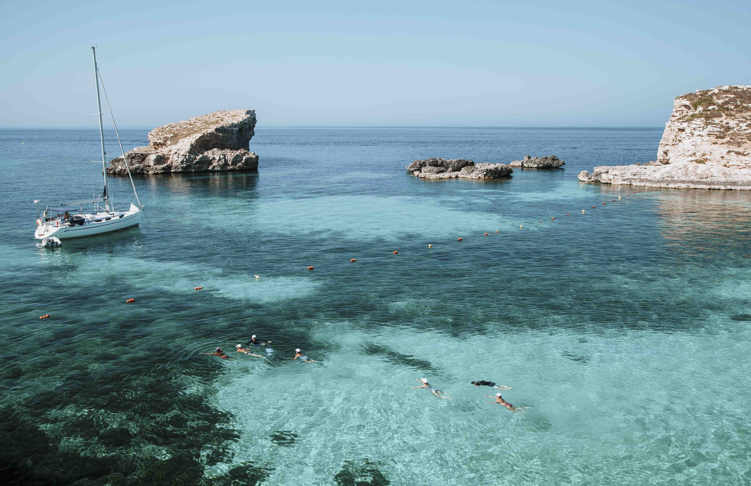 People swimming near the blue lagoon malta on trips to malta
