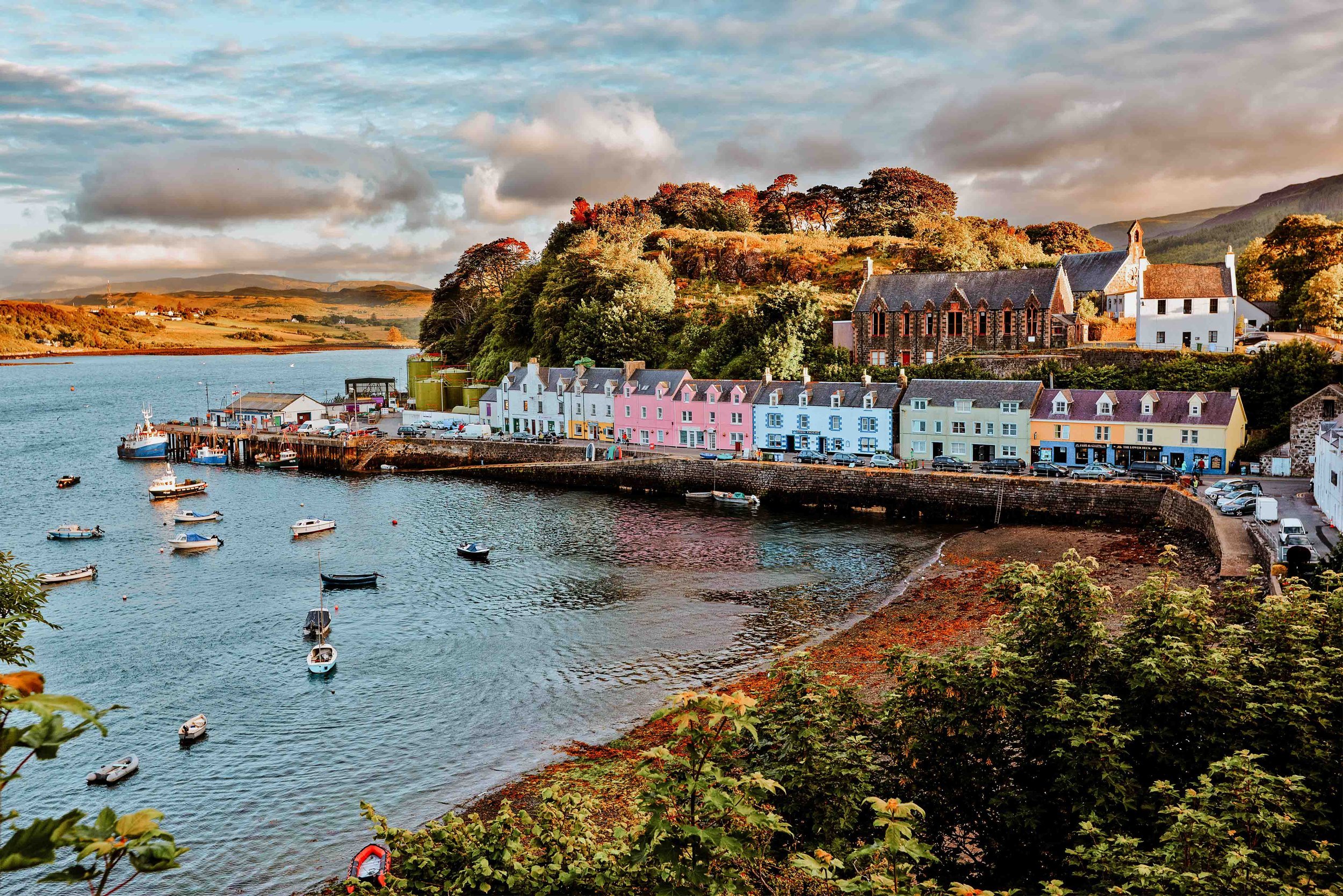 Colourful houses by the sea with boats in Skye place to visit europe in the summer