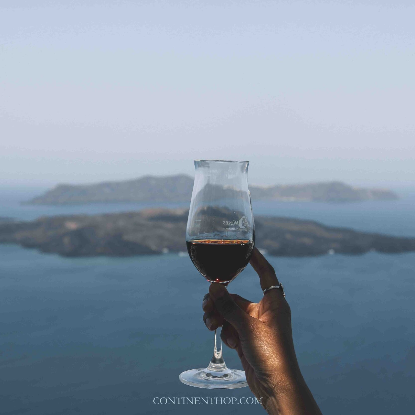 Woman holding glass of wine in Santorini in greece 7 days itinerary