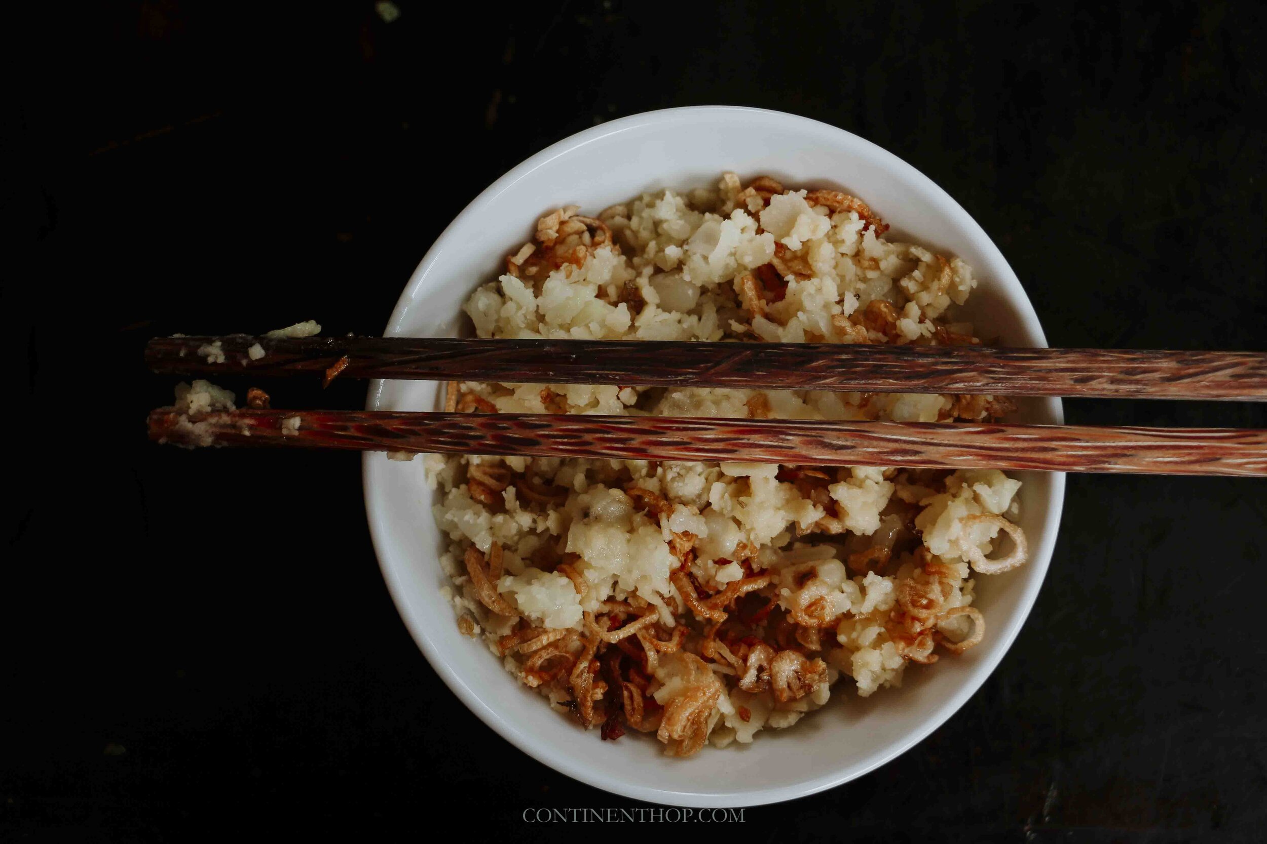 Image of a bowl with rice and noodles with the chopsticks over it in Hanoi Vietnam
