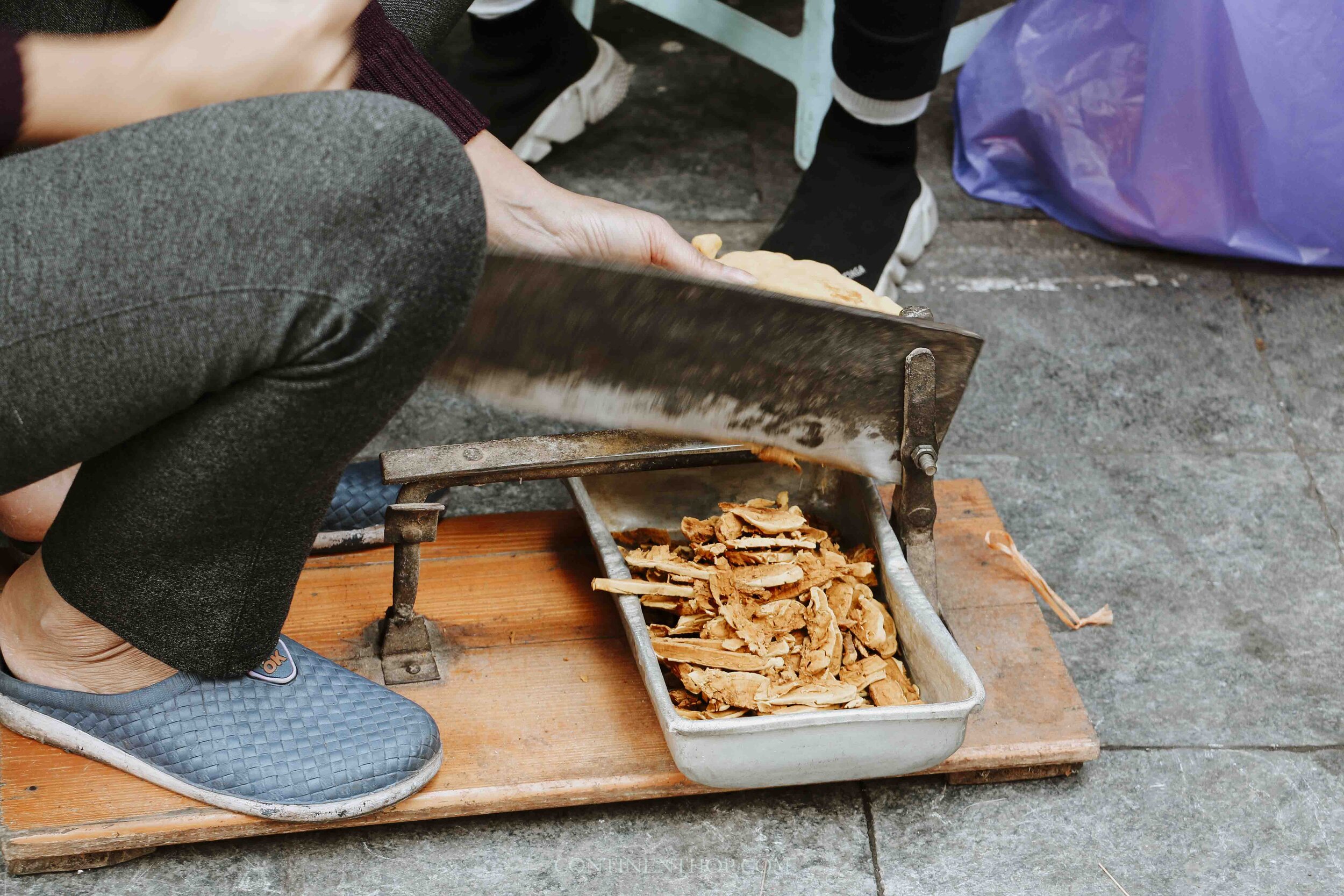 Image of woman breaking cinnamon into small pieces in Hanoi Vietnam