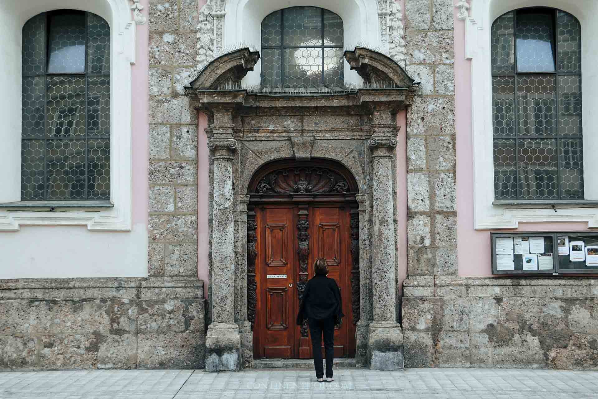 lady standing outside pink building on Maria Theresein strasse in Innsbruck