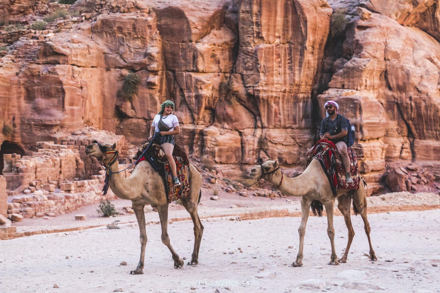 Woman riding camel inside petra jordan while visiting petra