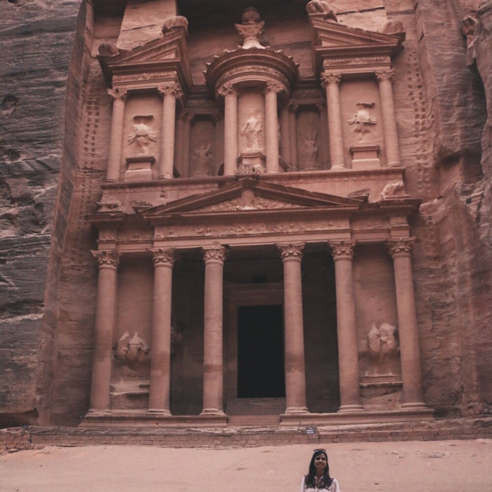 woman standing in front of petra treasury inside petra jordan