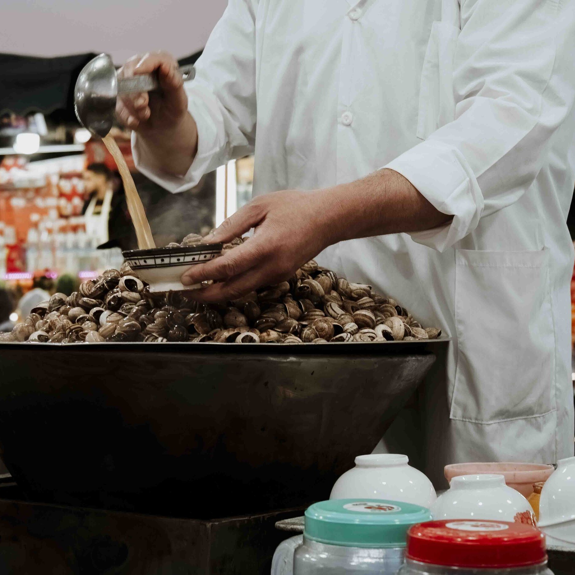 hawker selling snails at marrakech market in djema el fna