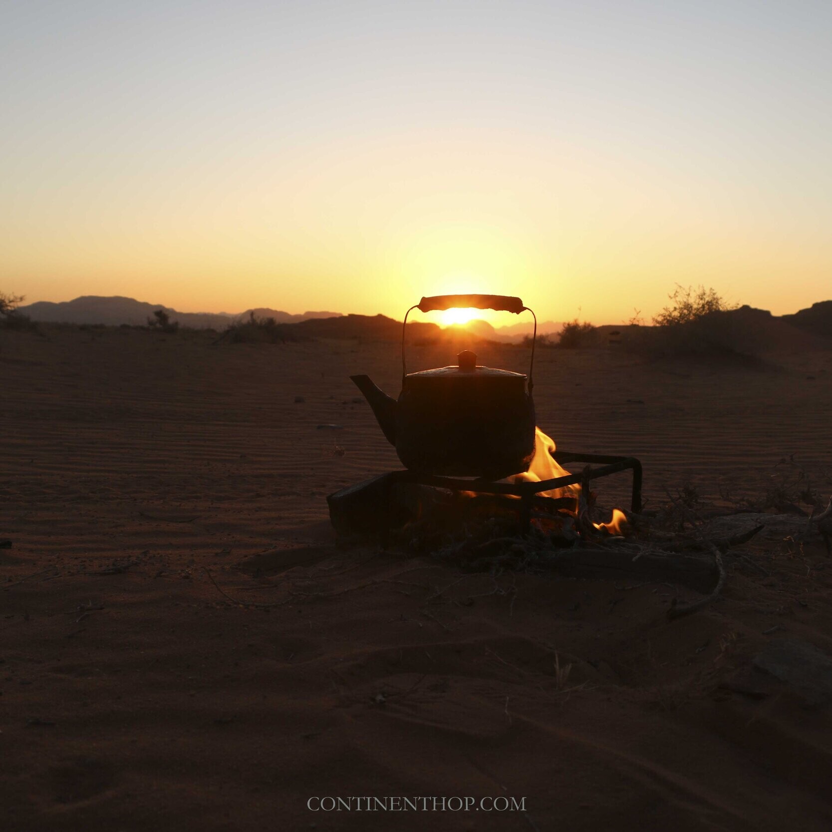 Jordan country image of a kettle placed on firewood and flames at sunset in Wadi Rum
