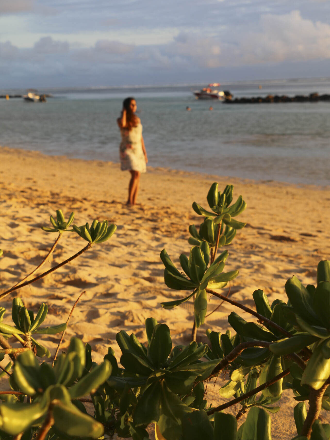 Woman standing on a beach in Mauritius during sunset