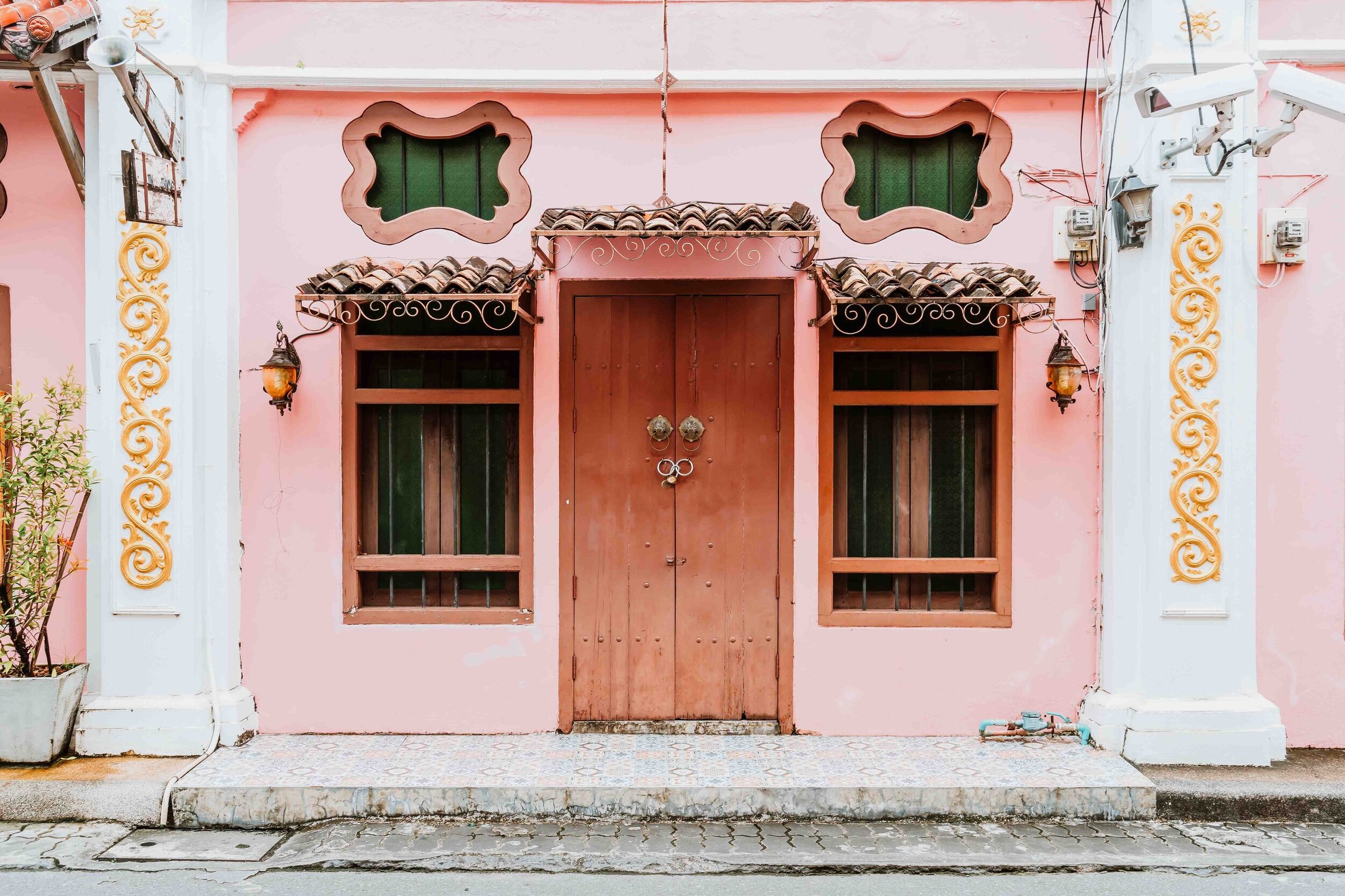 Pink building with pretty brown door in phuket in june in thailand