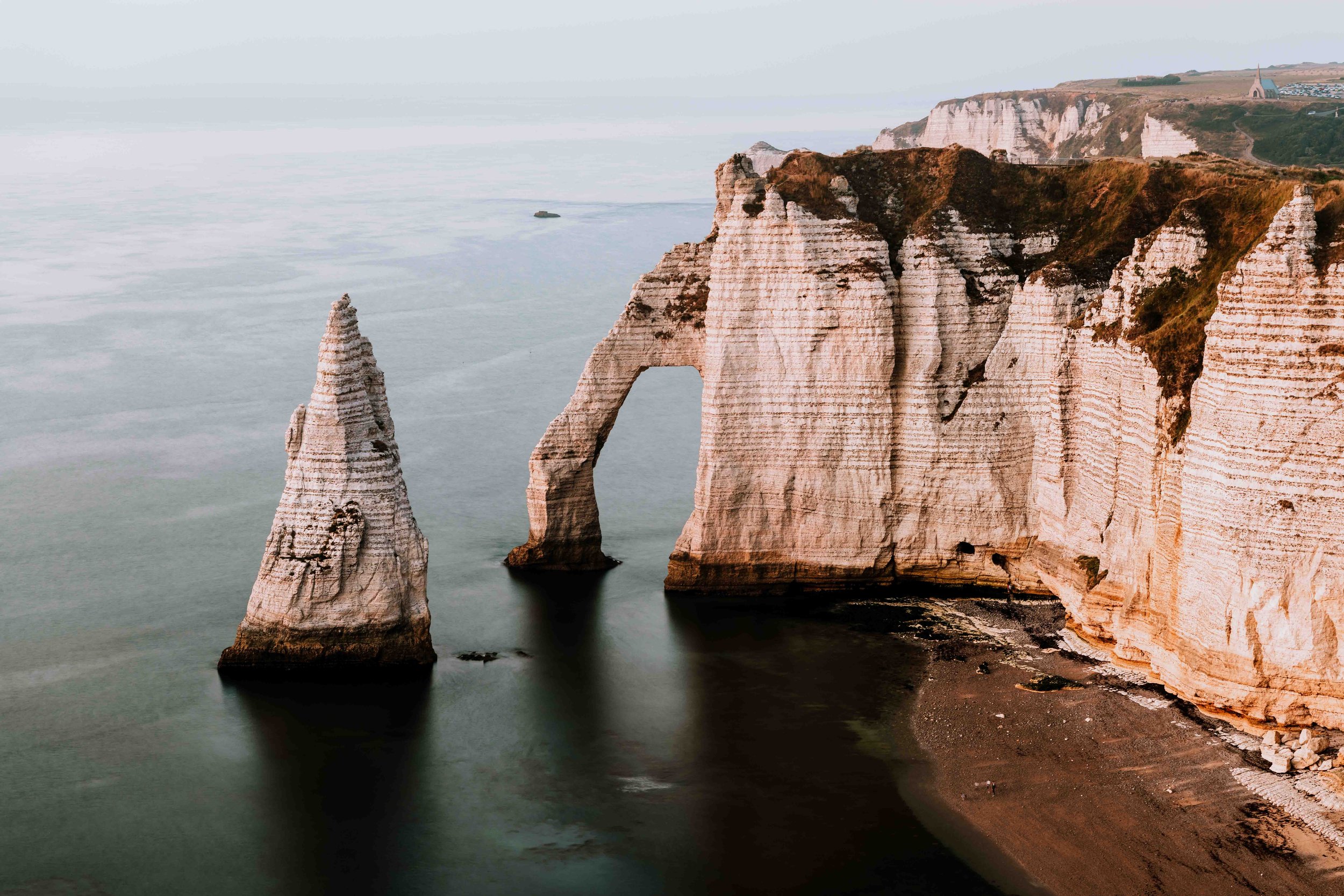 Cliffs of Etretat at sunset by the sea on a road trip to Normandy itinerary