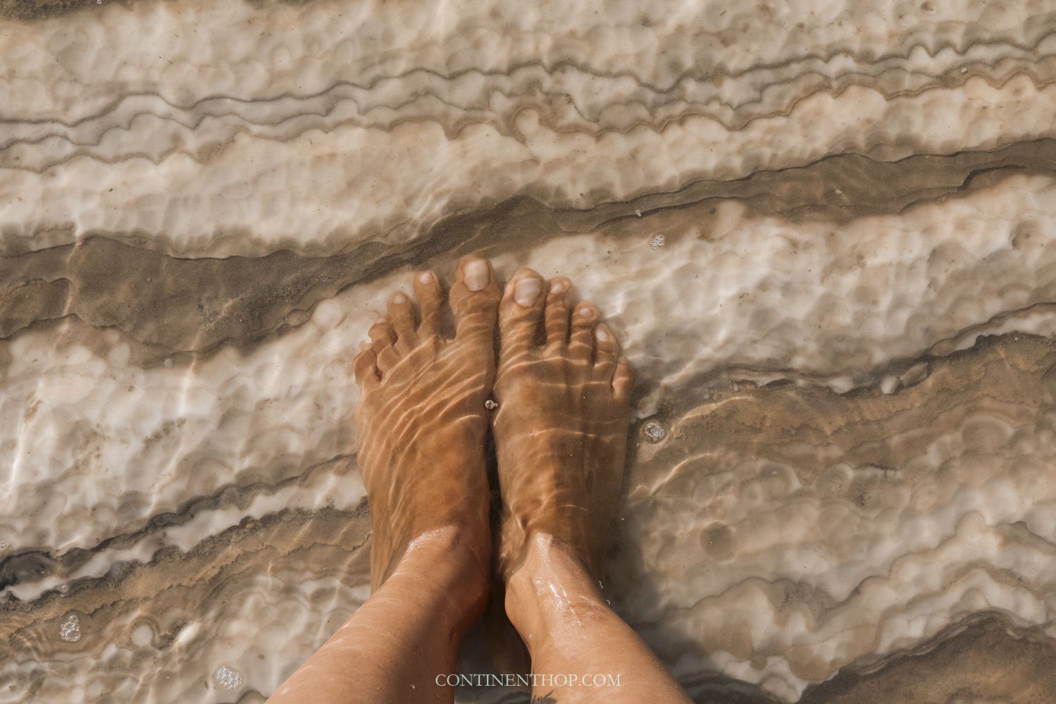 Woman with feet in the dead sea jordan