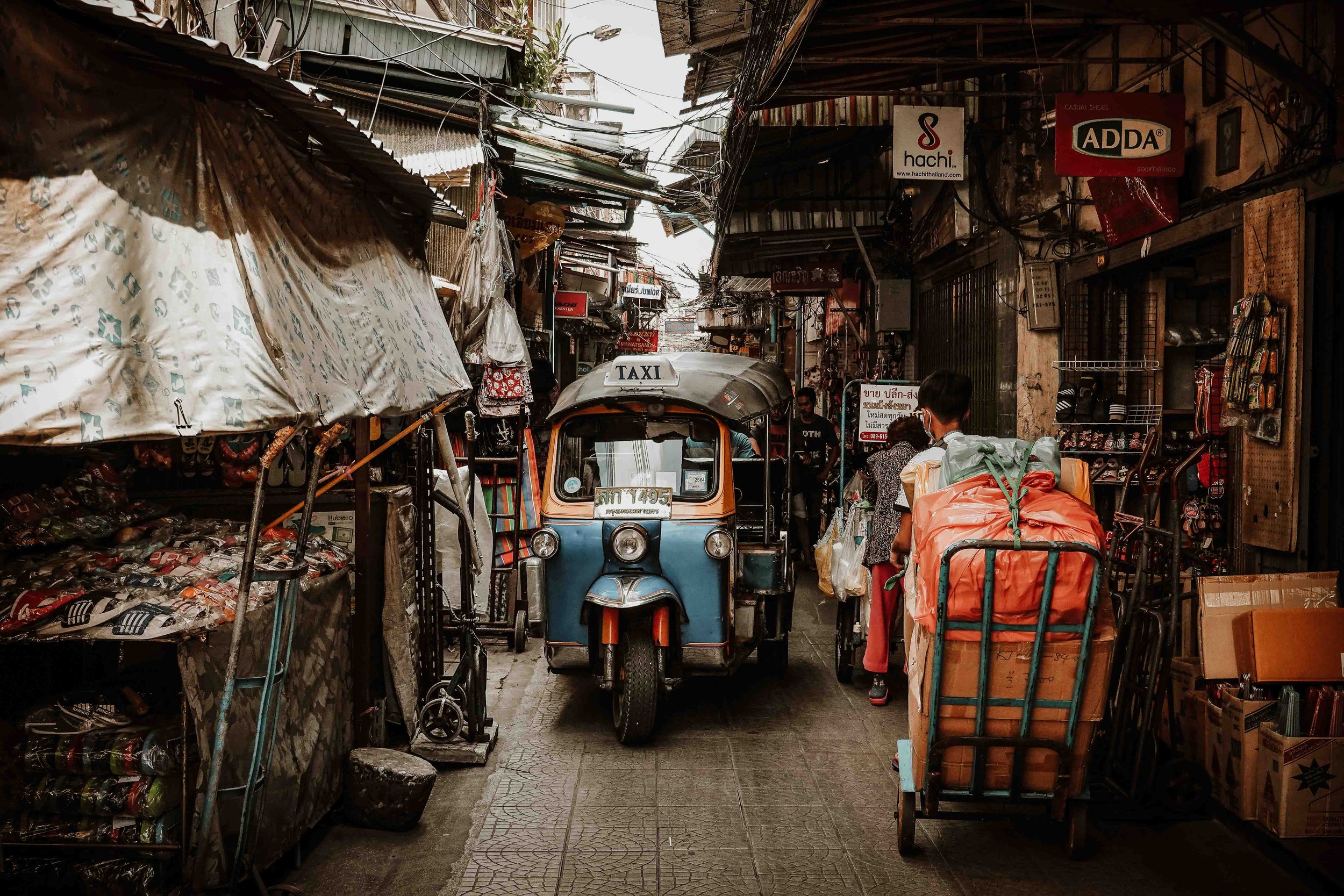 A tuk tuk passing through a street market in Thailand on 4 weeks in thailand