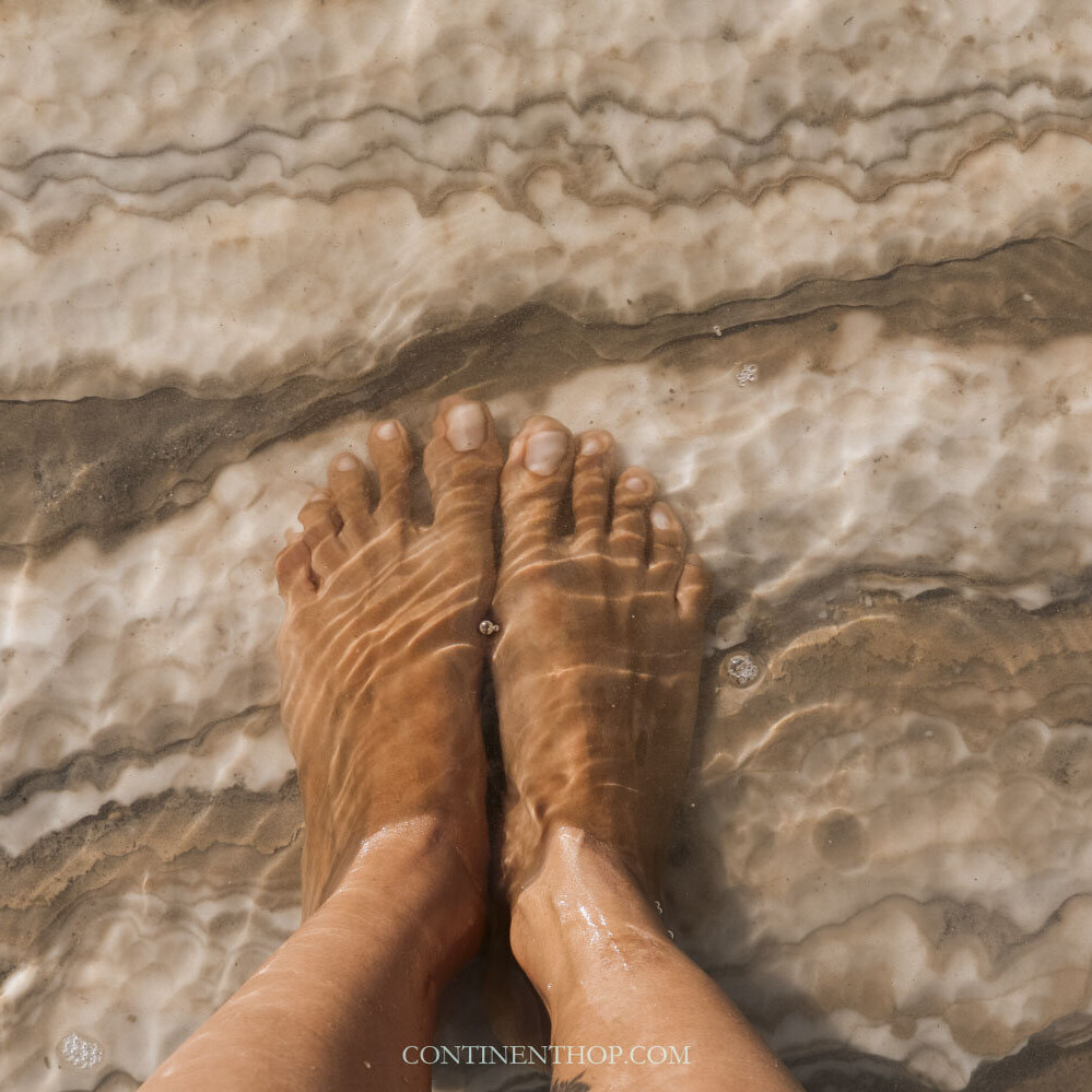 Woman standing with her feet in the dead sea
