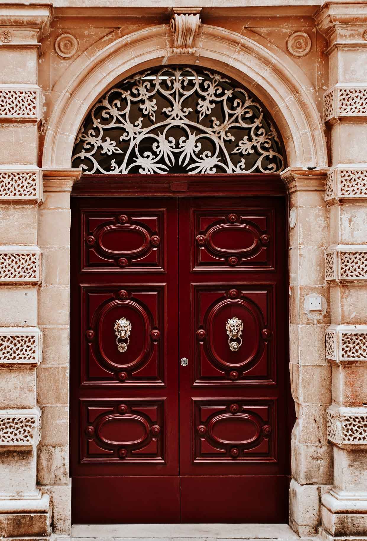 A red door with lion knockers inside Mdina from Valletta to Mdina