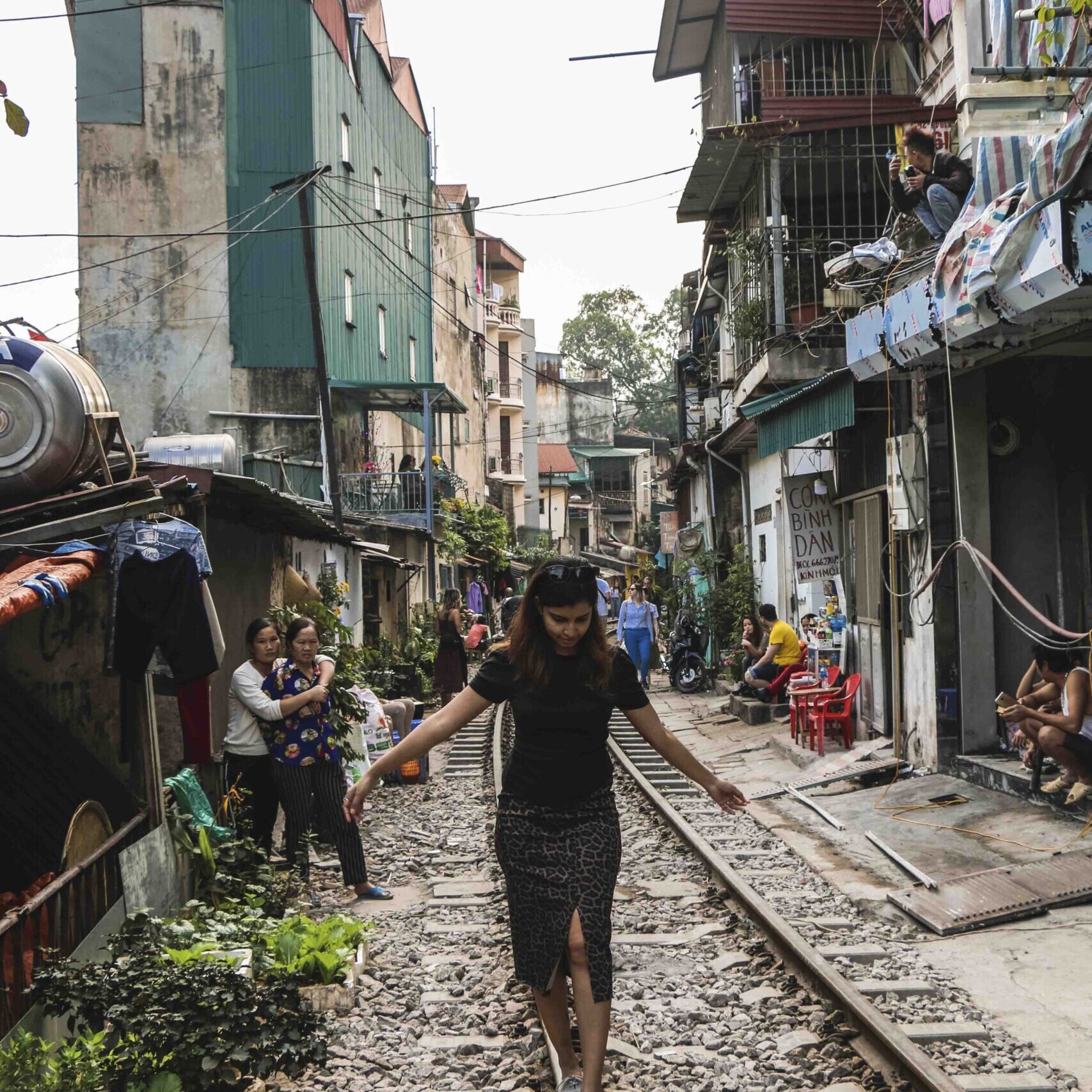 girl walking on a railway track in one day in Hanoi itinerary