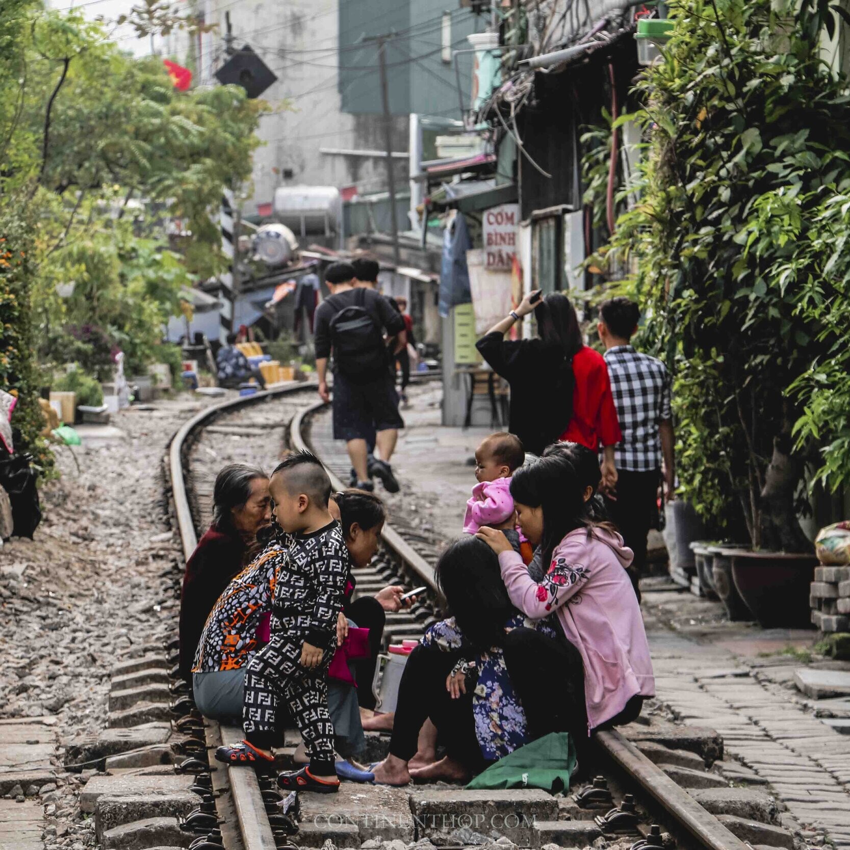 people sitting on a railway track in one day in Hanoi itinerary