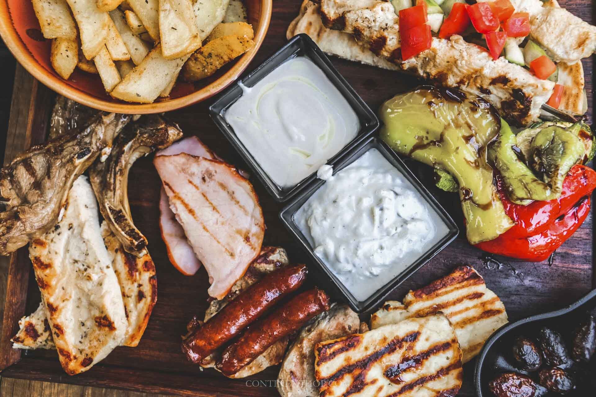 a traditional cyprus food meze of halloumi, cypriot sausage, gemista, tzatziki dips and grilled meat